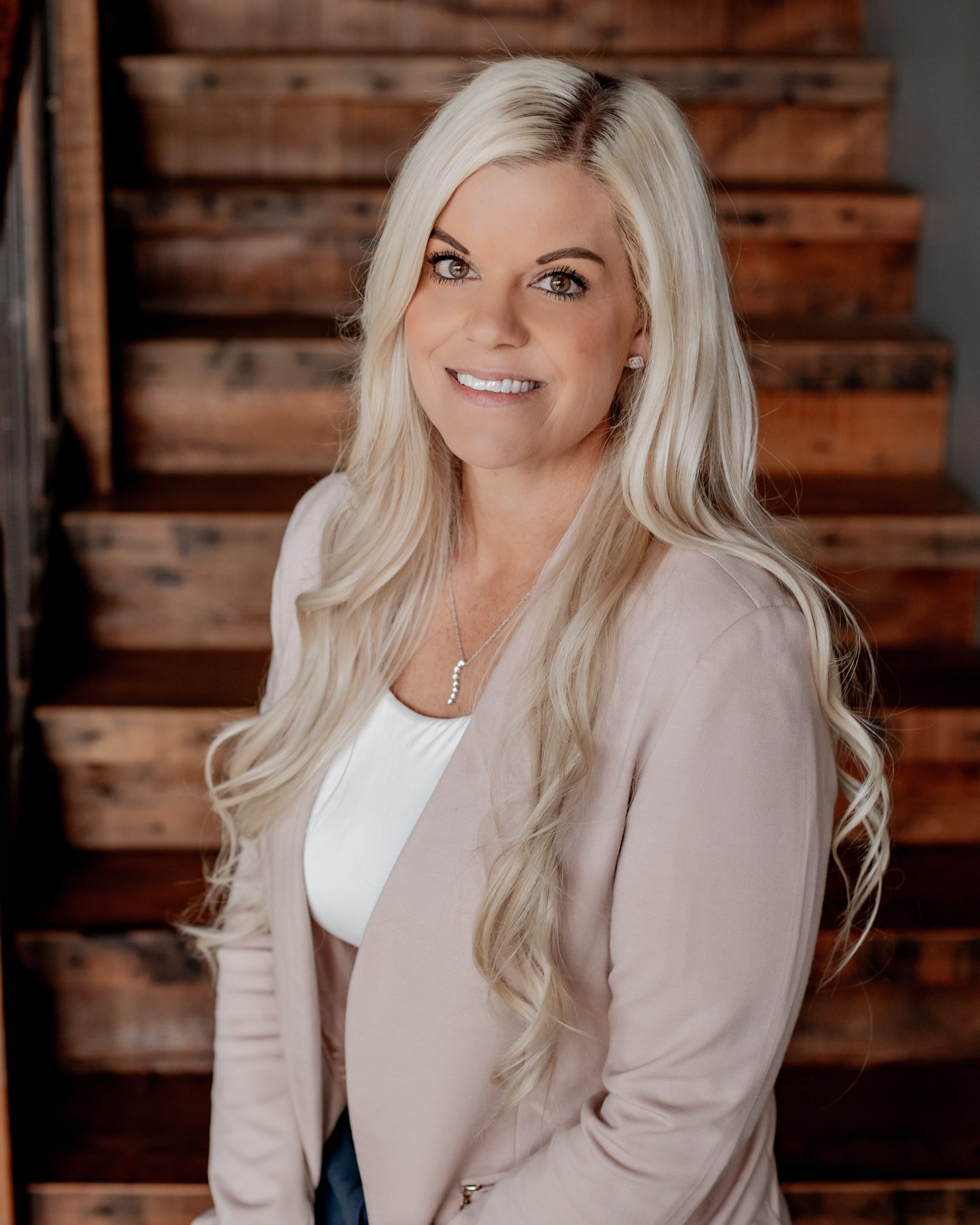 Professional headshot of Samantha Gibbos wearing a light pink blazer and white top.
